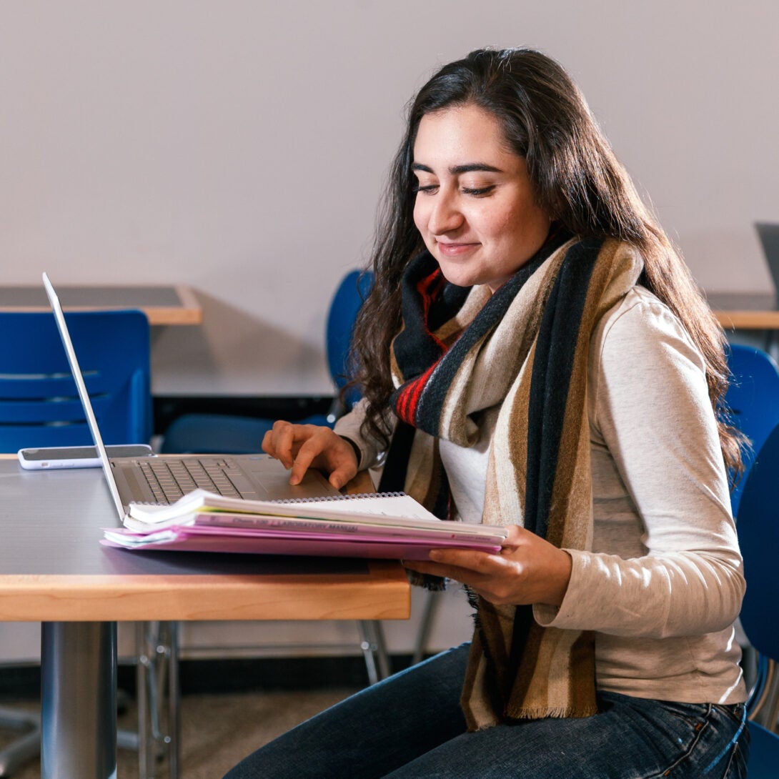 Graduate student pursing an online master's degree works on her laptop.